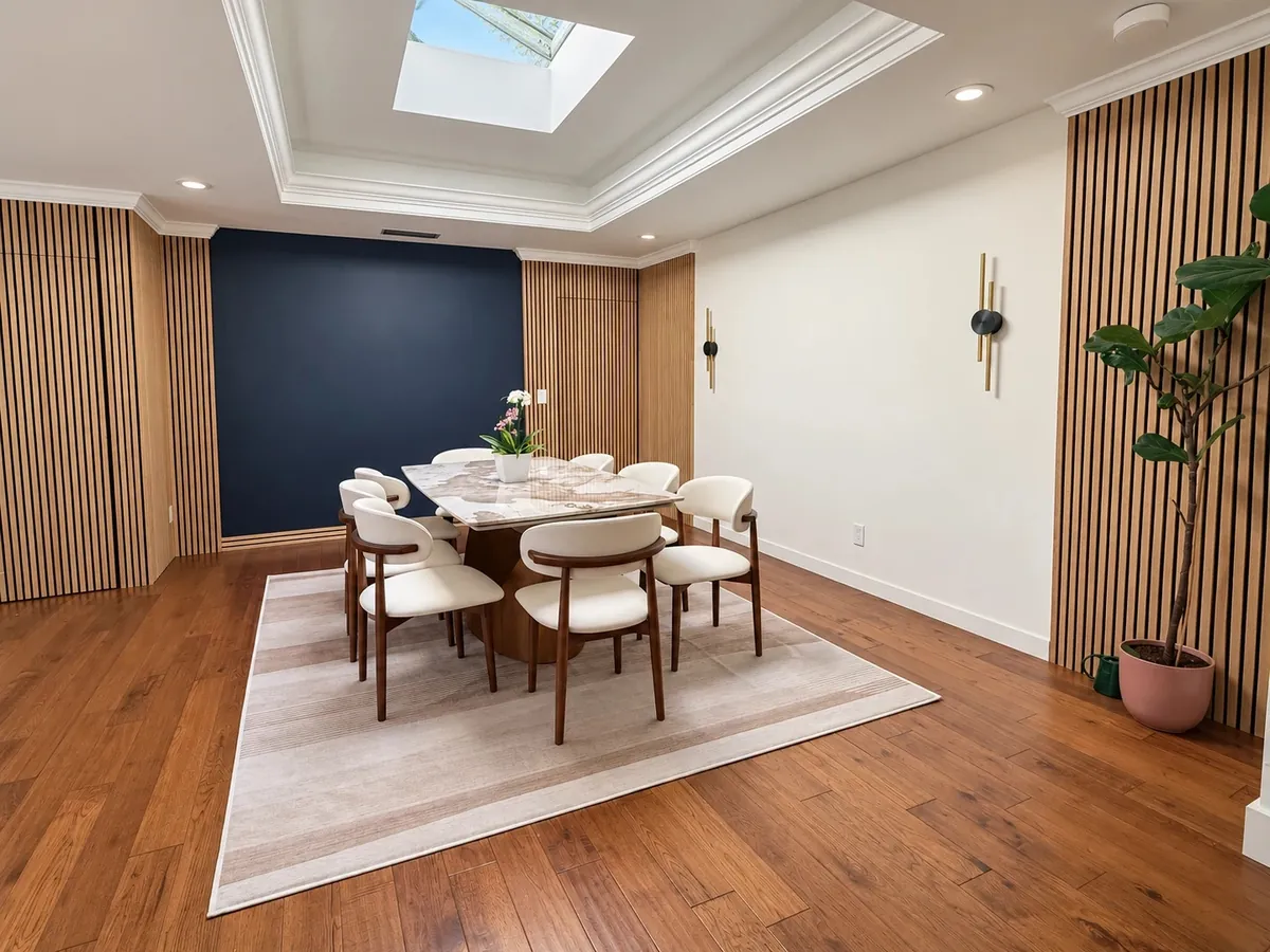 Dining room with wood slat walls, walnut chairs and a skylight